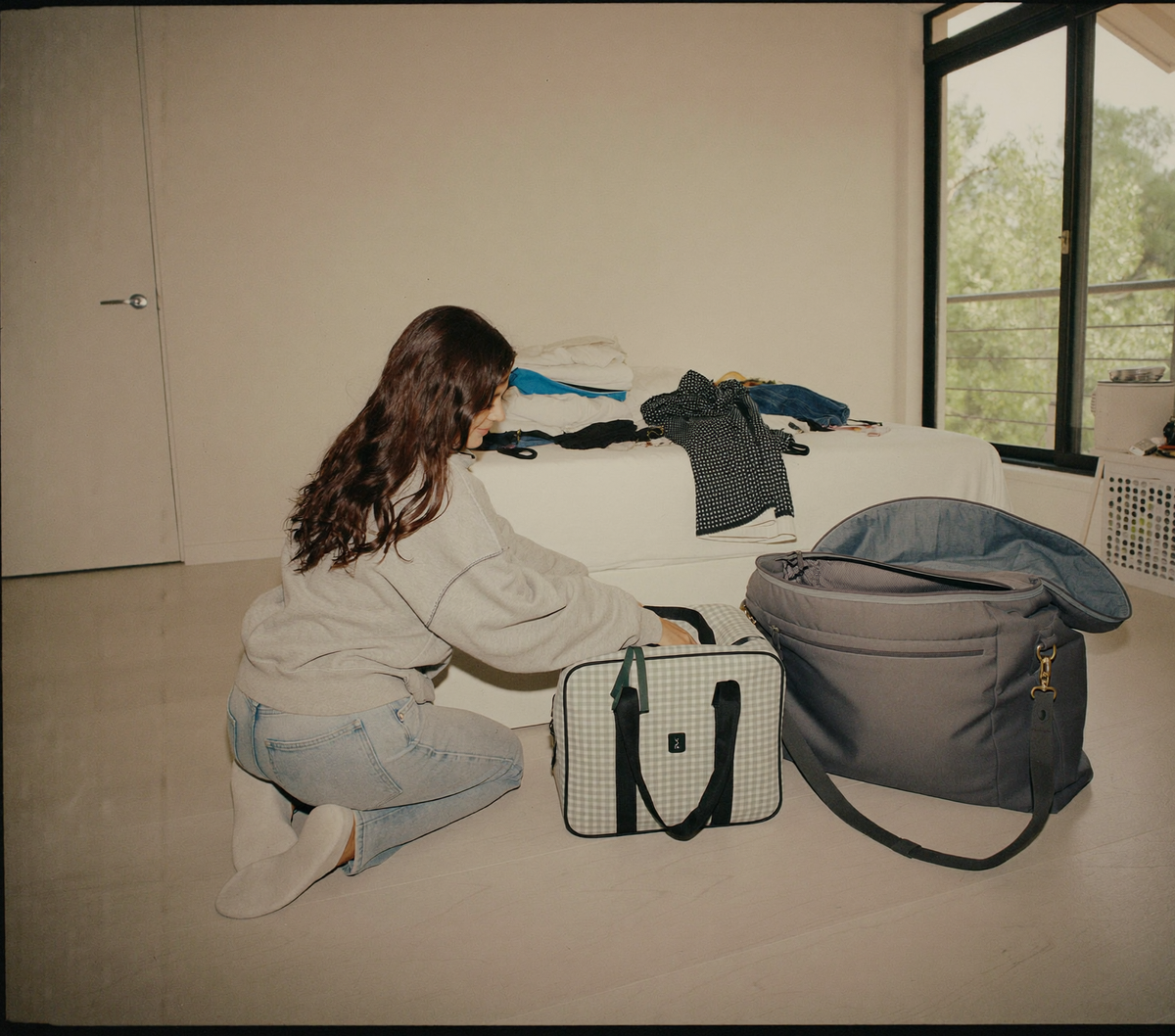 Deux sacs de voyage de contenances differentes poses cote a cote avant un depart